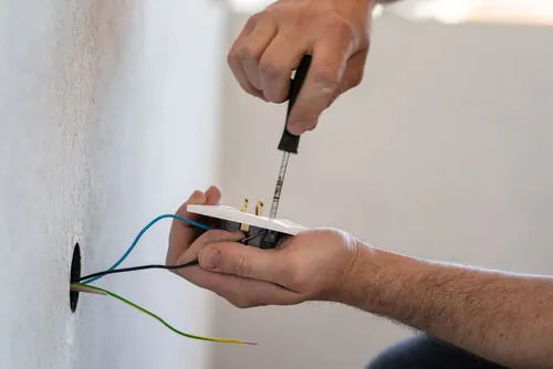 Electrician fitting a new socket during house rewiring in Leicestershire