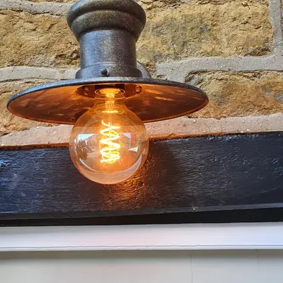 Outdoor lantern installed on a stone wall
